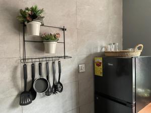 una cucina con un frigorifero nero e utensili su una parete di Tamaniroom- a private 1bed a Tamale