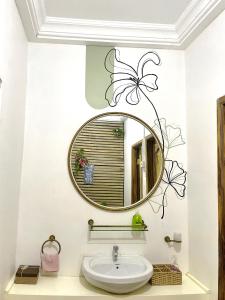 a bathroom with a round mirror and a sink at Tamaniroom- a private 1bed in Tamale