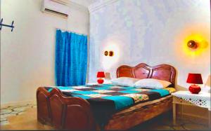 - une chambre avec un lit et 2 lampes dans l'établissement Appartement Berbère, à Tozeur