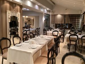 a restaurant with white tables and chairs and a mirror at Οικία αποζαρι μικρή περσα in Kastoria