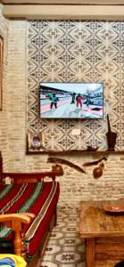 - un salon avec une télévision suspendue au mur dans l'établissement Appartement Berbère, à Tozeur