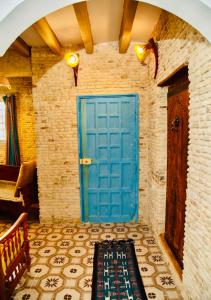 a blue door in a room with a tile floor at Appartement Berbère in Tozeur