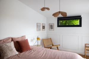 a bedroom with a bed and a window and a chair at Lieu de Vie & d'Expériences dans l'Ouest Bordelais in Le Bouscat