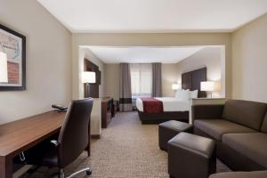 a hotel room with a bed and a couch and a desk at Comfort Inn Onalaska - La Crosse Area in Onalaska