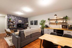 a living room with a couch and a table at Adorable 2-Bedroom Modern Basement in Denver