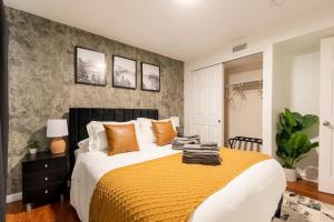 a bedroom with a large bed with orange pillows at Adorable 2-Bedroom Modern Basement in Denver