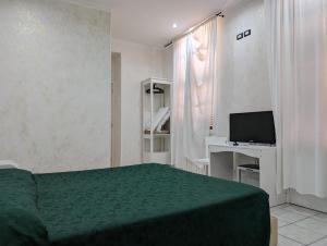 1 dormitorio con 1 cama verde y TV en Pollon Inn Sanremo, en San Remo