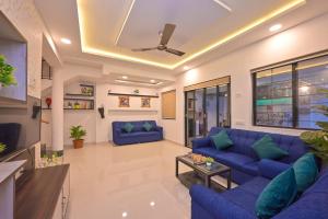 a living room with blue couches and a ceiling at Great Escape Villa by Tropicana Stays in Lonavala