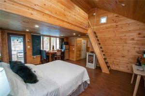 - une chambre avec un lit dans une cabane en bois dans l'établissement 3 Waterfront Cottages on Lake Sparrow - Sleeps 16, à Severn