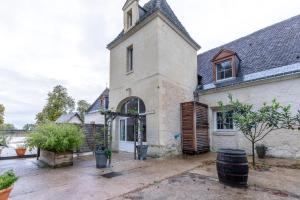 un antiguo edificio con una torre de reloj encima en Gîtes de la Bigauderie, en Montlouis-sur-Loire