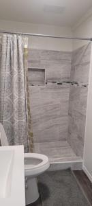 a bathroom with a shower and a white toilet at Be Our Guest-Shared Home Tampa in Palmdale