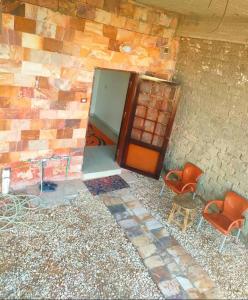 um quarto com duas cadeiras e uma porta num edifício em Mooody nobin haws em Abu Simbel