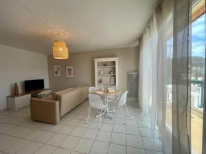 uma sala de estar com uma mesa e um sofá em CHEZ JOYCE Appartement cocooning em Lons-le-Saunier