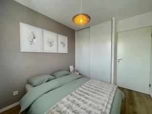 um quarto com uma cama e duas fotografias na parede em CHEZ JOYCE Appartement cocooning em Lons-le-Saunier