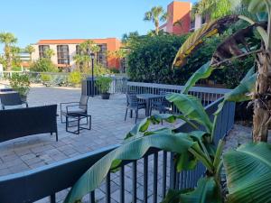 un patio con sillas, mesas y una valla en Grand Hotel Orlando at Universal Blvd - Shuttle to Theme Parks en Orlando