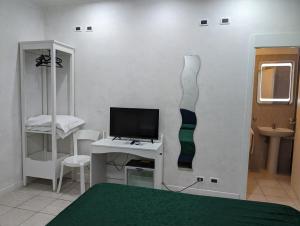 Habitación con TV y un vestido en la pared. en Pollon Inn Sanremo, en San Remo