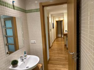 a bathroom with a sink and a mirror and a hallway at Piso nuevo totalmente equipado in Toro
