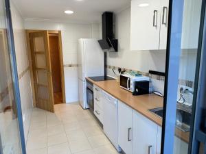 托羅的住宿－Piso nuevo totalmente equipado，厨房配有白色橱柜和白色冰箱。