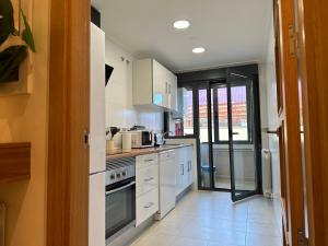 a kitchen with white cabinets and a stove top oven at Piso nuevo totalmente equipado in Toro +9 photos