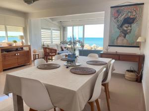 y sala de estar con mesa de comedor y sillas. en Sweet Home SXM Baie Nettlé Pieds dans l'eau en Saint Martin