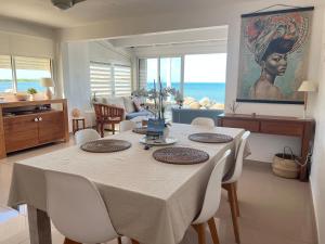 a dining table and chairs in a living room at Sweet Home SXM Baie Nettlé Pieds dans l'eau in Saint Martin