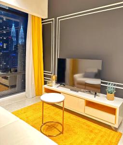 a living room with a tv and a chair and a table at Axon Residence Bukit Bintang By TR Suites in Kuala Lumpur