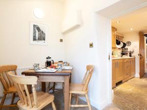 a kitchen with a wooden table and chairs at 2 Storrs Cottages in Carnforth