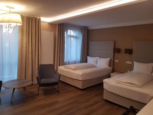 una habitación de hotel con 2 camas y una silla en Atlantic Boutique, en Târgu Mureș