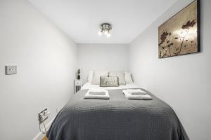 ein Schlafzimmer mit einem Bett mit zwei Handtüchern darauf in der Unterkunft CosyLiving Apartments London Paddington in London