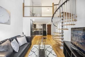 ein Wohnzimmer mit einem Sofa und einer Wendeltreppe in der Unterkunft CosyLiving Apartments London Paddington in London