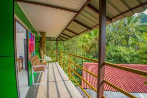 a balcony of a house with a table and a chair at NUTMEG COUNTY THABORE in Paithalmala +5 photos