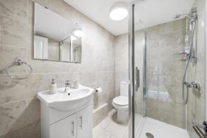 ein Bad mit einem WC, einem Waschbecken und einer Dusche in der Unterkunft CosyLiving Apartments London Paddington in London