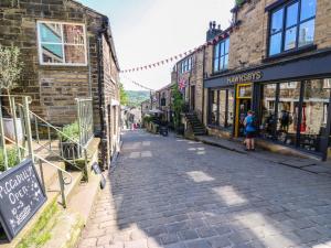 a cobblestone street in an old town with buildings at Emerald Cottage in Keighley