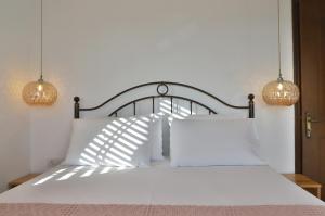 a bedroom with a white bed with two lights at Aqua Bliss in Xerokampos