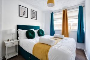 1 dormitorio con 1 cama grande con almohadas verdes en LIVERPOOL HOME with FREE PARKING, en West Derby