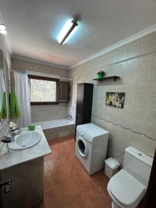 a bathroom with a white toilet and a sink at Casa El Sotillo in Almería