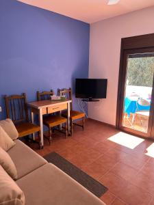 a living room with a couch and a table and a tv at Casa El Sotillo in Almería