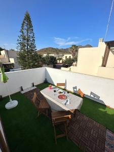 a patio with a table and chairs on a lawn at Casa El Sotillo in Almería