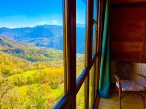 a chair sitting on a porch looking out of a window at Gentry House in Ambrolauri