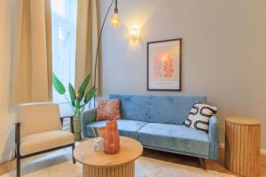 sala de estar con sofá azul y mesa en Central Designer 2 bedroom Flat en Budapest