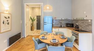 cocina con mesa, sillas y nevera azul en Central Designer 2 bedroom Flat en Budapest