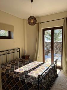 a bedroom with a bed and a sliding glass door at Mountain House Eptalofos in Eptalofos