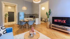 sala de estar con TV y mesa con sillas en Central Designer 2 bedroom Flat en Budapest