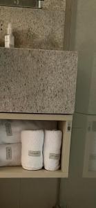 a row of towels on a shelf in a bathroom at Flat Jade Hotel Brasília in Brasilia