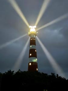 un faro con la luz encima en Appartement, Amelander Kaap 121 en Hollum