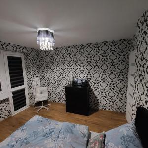 a bedroom with a bed and a chandelier at Apartament Chopina 17 in Włocławek