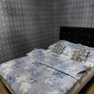 a bed with a blue and white comforter on it at Apartament Chopina 17 in Włocławek