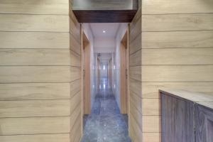 um corredor com paredes com painéis de madeira e um longo corredor em Capital O 75709 Hotel Spring Residency em Mumbai