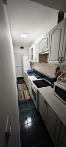 eine Küche mit weißen Schränken und weißen Geräten in der Unterkunft Apartment Capt Seferovic in Donji Morinj