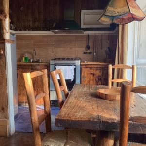 a kitchen with a wooden table and chairs and a kitchen with a stove at Cabañas Hermansen in Maitencillo